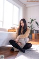 A woman sitting on the floor in a living room.