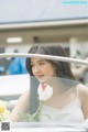 A woman in a white dress holding a white rose.