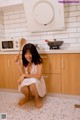 A woman sitting on the floor holding a wooden spoon.