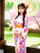 A woman in a kimono holding an umbrella.