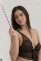 A woman in a black lingerie holding a wand.