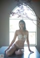 A woman in a white lingerie sitting on a table.